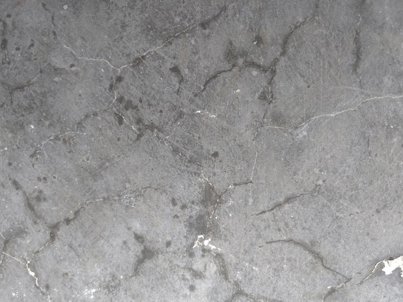 Bare, stained concrete garage floor before coating